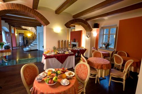 een restaurant met tafels en stoelen met fruit erop bij Hotel Cascina Di Corte in Venaria Reale