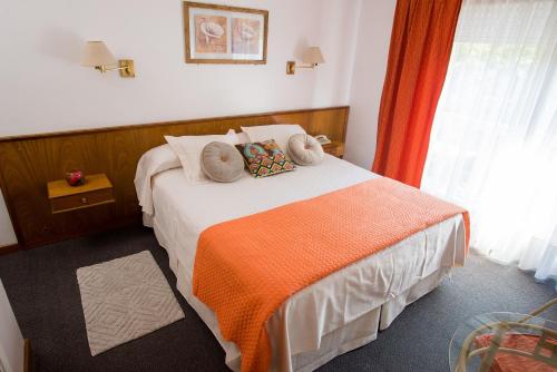 Habitación de hotel con cama con manta naranja en Hotel España, en Mar del Plata