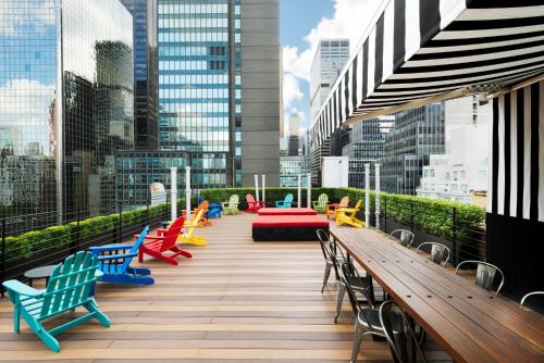 eine Terrasse mit bunten Stühlen und Tischen in einer Stadt in der Unterkunft Pod 51 in New York