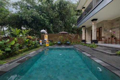 a swimming pool in the backyard of a house at Puri Astina Villa in Ubud