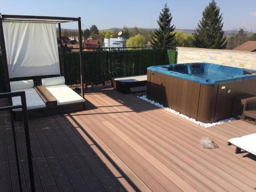 a deck with a hot tub and a table and bench at Pensiunea El Passo Targu Mures in Târgu-Mureş