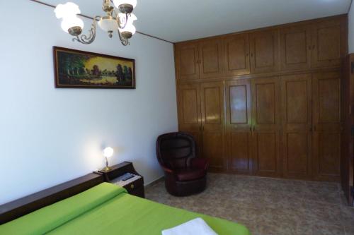 una camera con un letto verde e una sedia di Departamento Centrico a Villa Carlos Paz