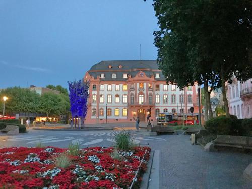 a large building with a lot of flowers in front of it at Osteiner Hof by The Apartment Suite in Mainz