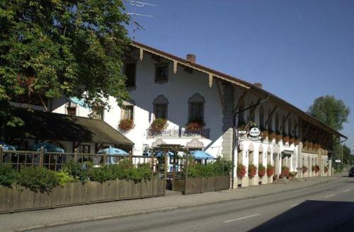 ein großes weißes Gebäude an der Straßenseite in der Unterkunft Gasthof-Hotel Höhensteiger in Rosenheim