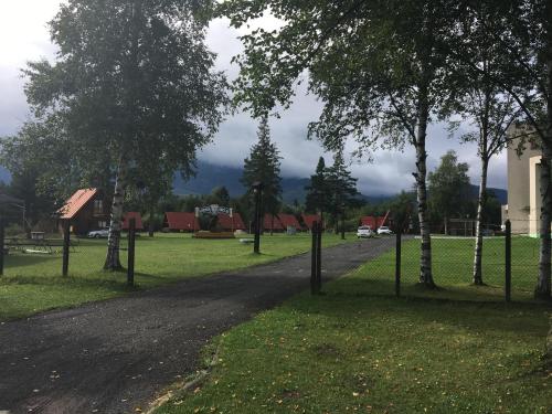 eine unbefestigte Straße in einem Park mit Bäumen in der Unterkunft Camping Intercamp Tatranec in Tatranská Lomnica