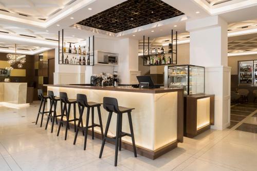 un bar in un ristorante con sgabelli neri di Hotel Europa Splendid a Merano