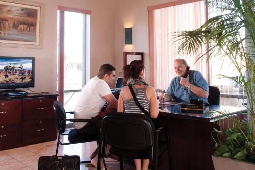 a group of people sitting at a desk in a room at Grand Canyon Plaza Hotel in Tusayan