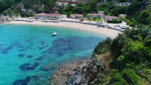 - une vue aérienne sur une plage avec un bateau dans l'eau dans l'établissement Hôtel Sampiero, à Propriano