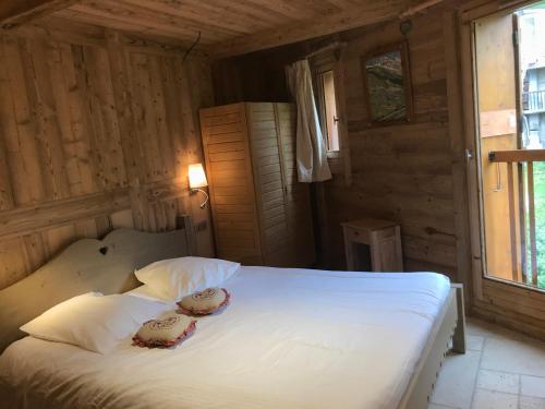 een slaapkamer met een bed met witte lakens en kussens bij Chalet Barmaz in Val dʼIsère