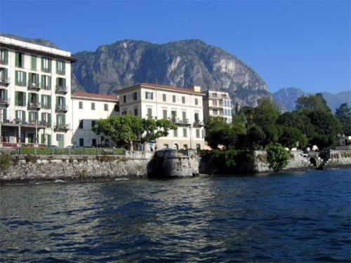 een groep gebouwen naast een waterlichaam bij Hotel Riviera in Griante Cadenabbia