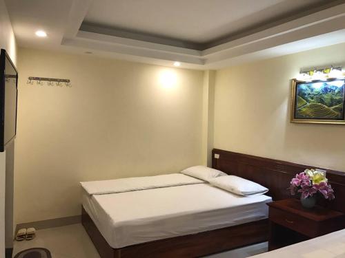 a bedroom with a bed and a picture on the wall at Camellia Guest House in Sa Pa