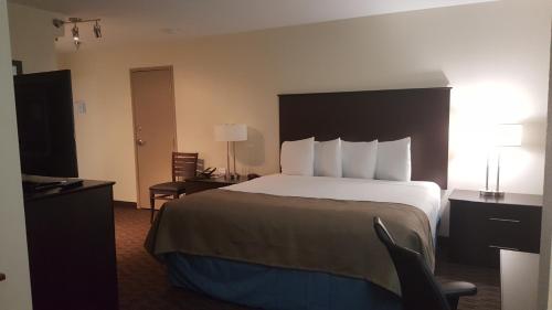 Rúm í herbergi á AmericInn & Suites Burnsville, MN