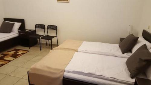 1 Schlafzimmer mit 2 Betten und 2 Stühlen in der Unterkunft Vis A Vis Studio in Bukarest