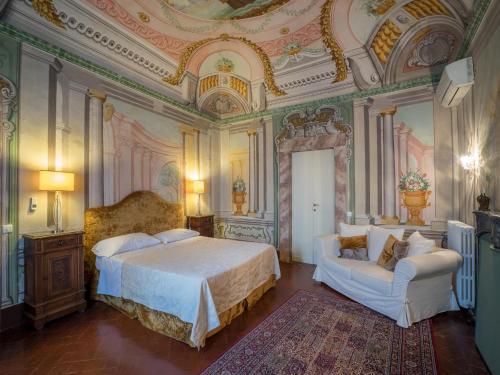 um quarto com uma cama e duas cadeiras em Hotel Villa Sermolli em Borgo a Buggiano