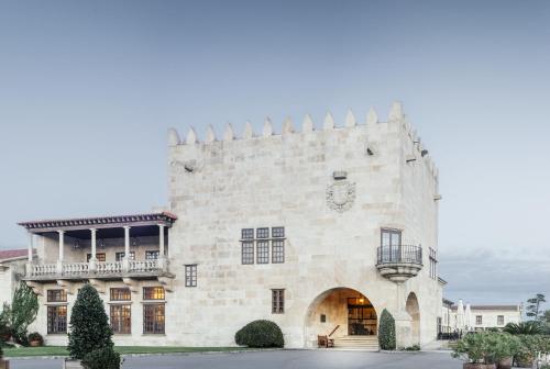 Un grand bâtiment blanc avec balcon est disponible. dans l'établissement Parador de Baiona, à Baiona