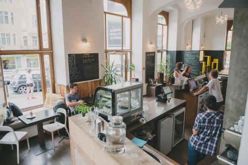 a restaurant with people sitting at tables and a counter at Czech Inn in Prague