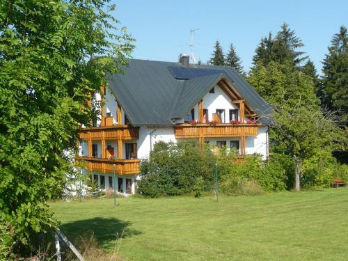 una grande casa in legno con tetto a gambero di Hotel Bergblick a Warmensteinach