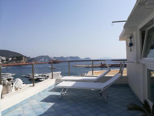 einen Balkon mit einer Bank und Blick auf das Wasser in der Unterkunft la mansarda sul Porto in Ponza