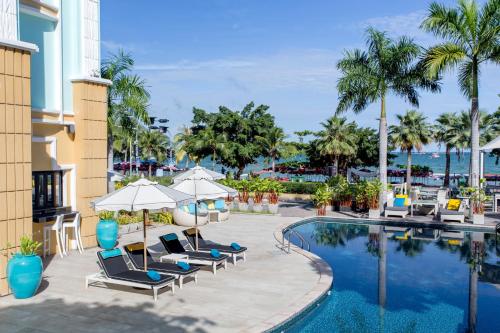 een zwembad in het resort met stoelen en parasols bij Wave Hotel Pattaya in Pattaya