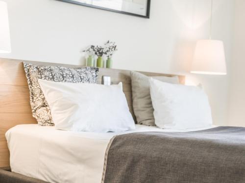 um quarto com uma cama com almofadas brancas em Restaurant-Hotel Maien em Lörrach