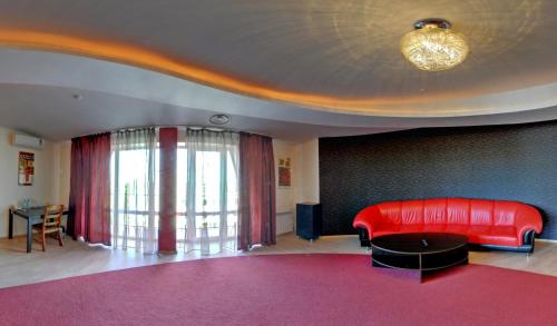 uma sala de estar com um sofá vermelho e uma mesa em Tsentralniy Hotel em Khmelnytskyi