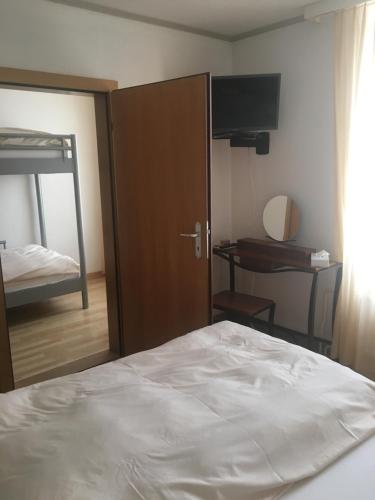 una camera con letto e porta con specchio di Hôtel de la Gare a Yvonand