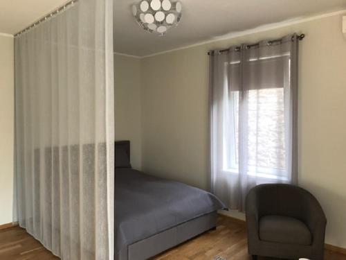 sypialnia z łóżkiem, krzesłem i oknem w obiekcie Apartment in Kalamaja w Tallinnie