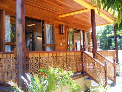 a house with a wooden railing on a porch at Baan Nana Villa in Mae Nam