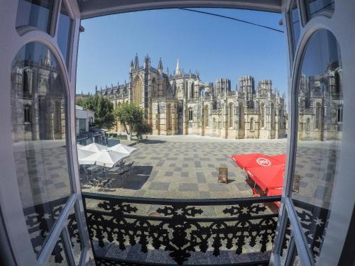 een uitzicht op een groot gebouw met een rode paraplu bij Mosteiro View in Batalha