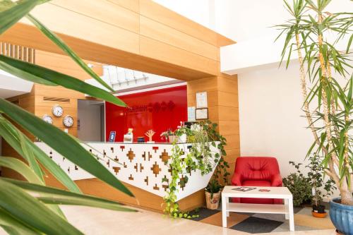 un vestíbulo con una silla roja y plantas en Horeum Boutique Hotel, en Sibiu