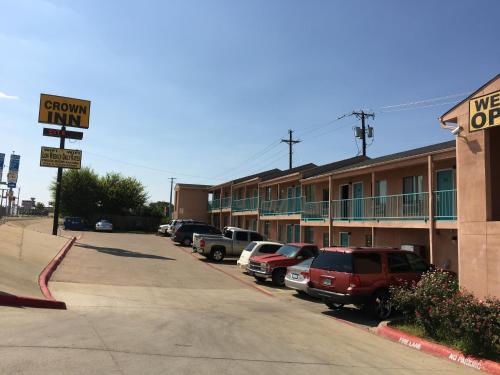 una strada con auto parcheggiate di fronte a un hotel di Crown Inn Grand Prairie a Grand Prairie