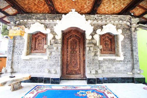 um quarto com uma grande porta de madeira num edifício em Yasa Homestay em Nusa Penida