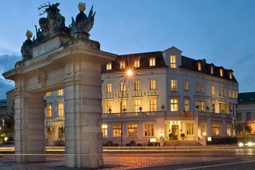 un grand bâtiment avec une statue en face dans l'établissement Hotel Am Jägertor, à Potsdam