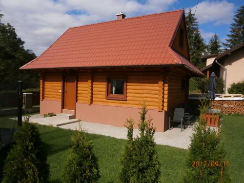 une cabane en rondins avec un toit rouge dans l'établissement Drevenica Silvia, à Liptovský Mikuláš