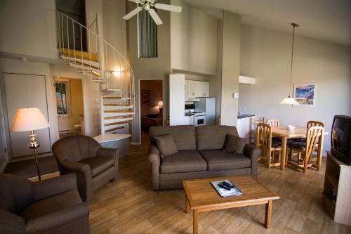 uma sala de estar com um sofá e uma mesa em Chalets Condos sur le Fjord em LʼAnse-Saint-Jean