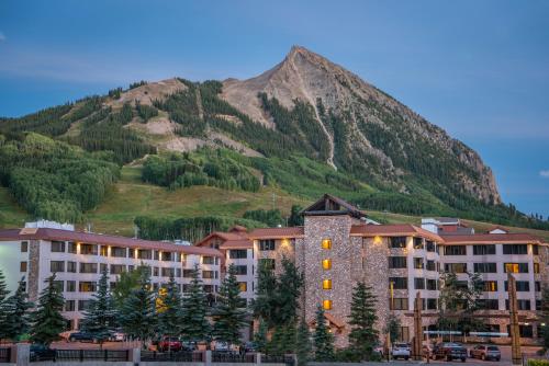 The Grand Lodge Hotel and Suites في Mount Crested Butte: مبنى كبير في خلفية جبل