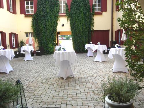 a group of tables with white table cloths in a courtyard at Gut Drasing in Krumpendorf am Wörthersee