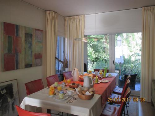 een eetkamer met een tafel met eten erop bij B&B Roseland in Brugge