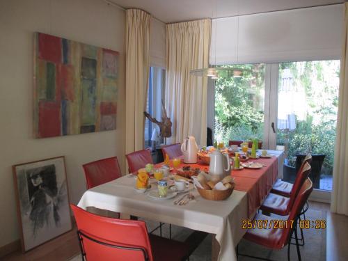 een eetkamer met een tafel met rode stoelen bij B&B Roseland in Brugge