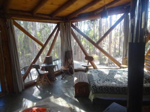 a room with a bed and a large window at Cabanas Curi-Huapi in Isla Negra