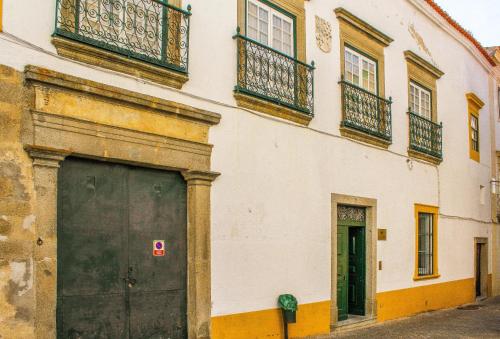 ein Gebäude mit einer großen Tür und einem Balkon in der Unterkunft Casa De S. Tiago in Évora