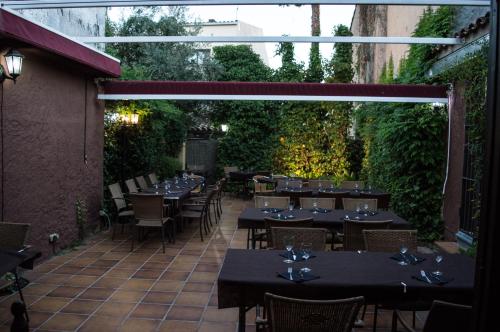 a restaurant with tables and chairs and a patio at L'Argolla Hotel-Pizzeria in Santa Coloma de Farners