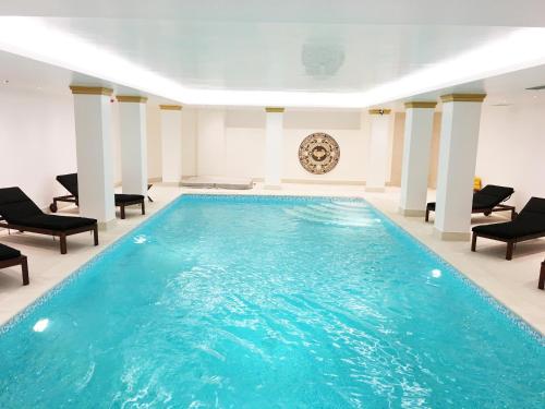 a pool in a room with chairs and a table at Theoxenia Palace in Athens