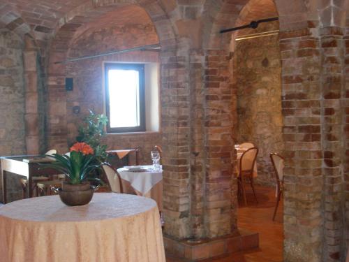 comedor con mesa y pared de ladrillo en Case Cordovani, en Magliano in Toscana