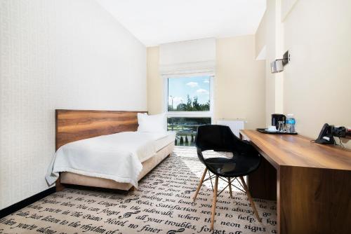 a bedroom with a bed and a desk and a chair at Hotel Piano in Lublin