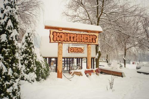 un panneau indiquant un restaurant recouvert de neige dans l'établissement Hotel Continent, à Polyana