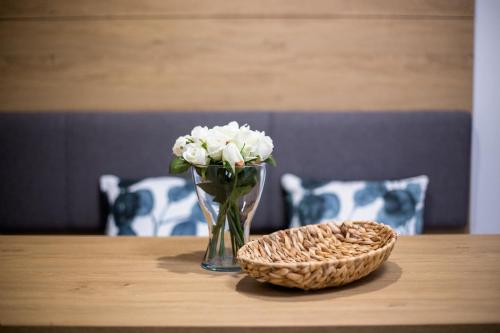 un vase de fleurs et un panier sur une table dans l'établissement Apartmány Na Čtvrtích, à Dolní Bečva