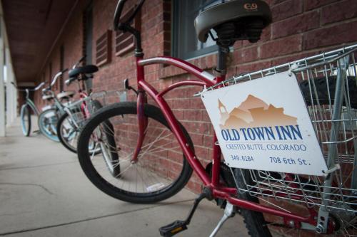 un vélo rouge avec un panneau sur le côté d'un bâtiment dans l'établissement Old Town Inn, à Crested Butte