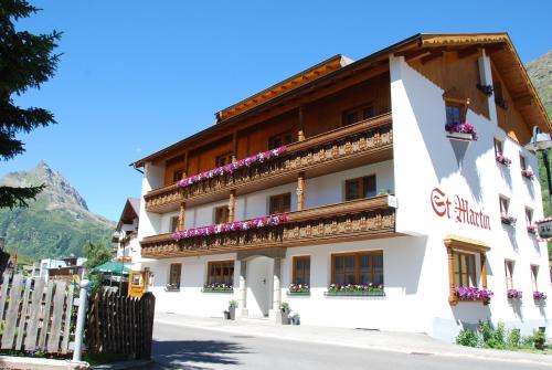 un edificio con fiori sui balconi di una strada di Apart Garni St Martin - Silvretta Card Premium Betrieb a Galtür