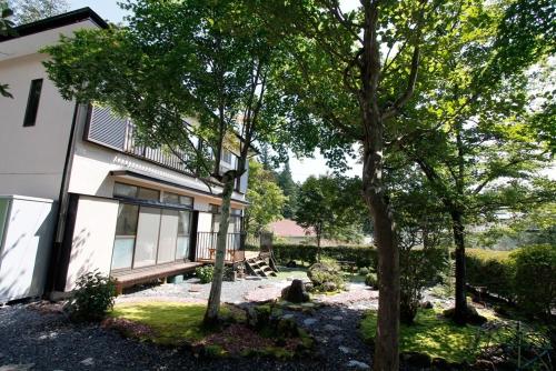 a house with a bench and trees in front of it at Midorian in Nikko